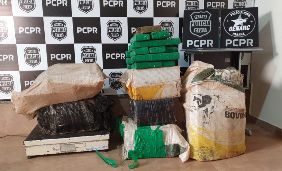 Pacotes com maconha são expostos em frente a banner da PCPR