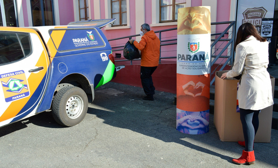 Agasalhos sendo transportados para veículo da defesa civil