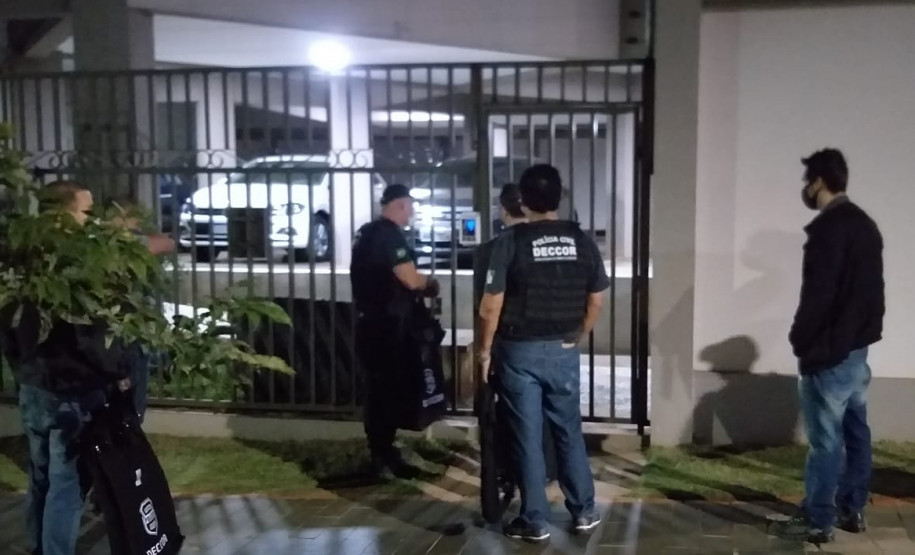 Policiais civis na calçada, em frente a local a ser investigado