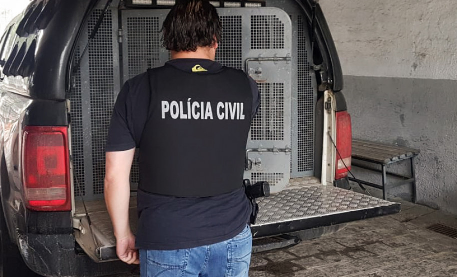 Policial civil ao lado de viatura