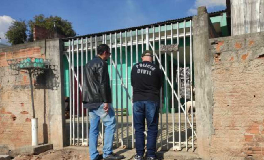 Dois policiais civis em frente à residência