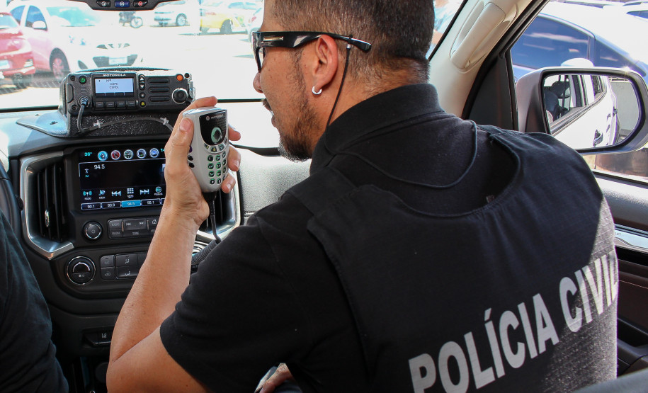 Policial civil falando por rádio em viatura