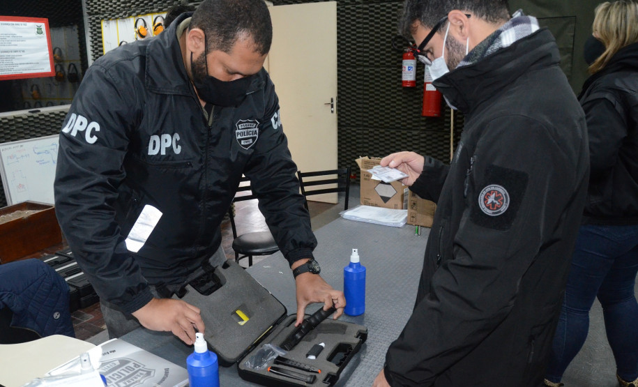 Aluno verificando numeração de arma recebida