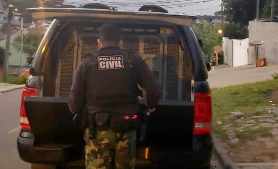 Policial civil atrás de viatura