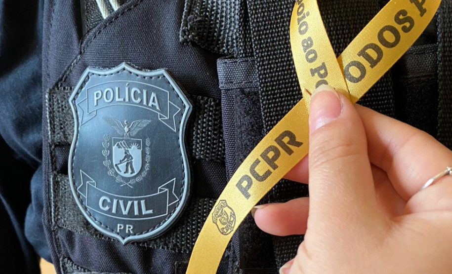 Policial civil com colete mostrando e fita