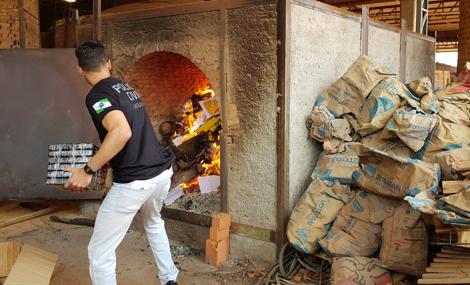 Policial civil arremessando tabletes de droga no incinerador
