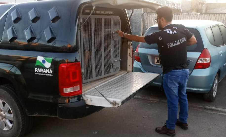 Policial civil fechando tampa do porta-malas de viatura