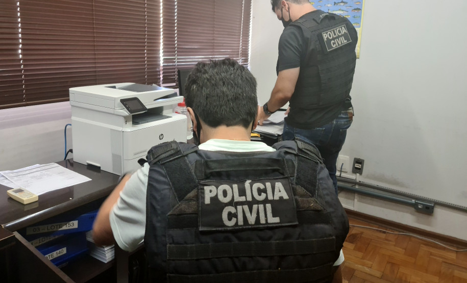 Policiais civis analisando documentos