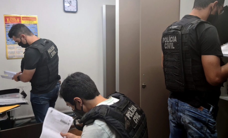 Policiais civis analisando documentos