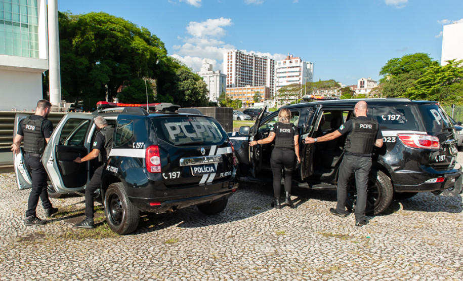 Policiais civis entrando em viaturas