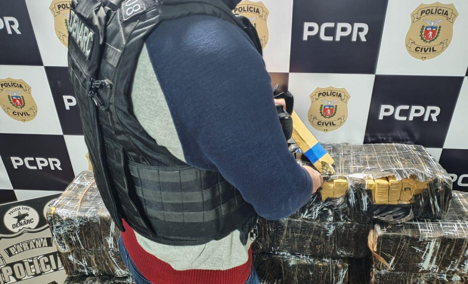 Policial civil empilhando droga apreendida