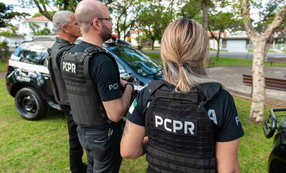 Três policiais civis de costas