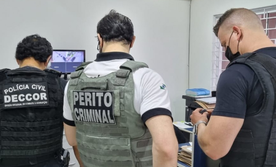 Policiais civis analisando documentos