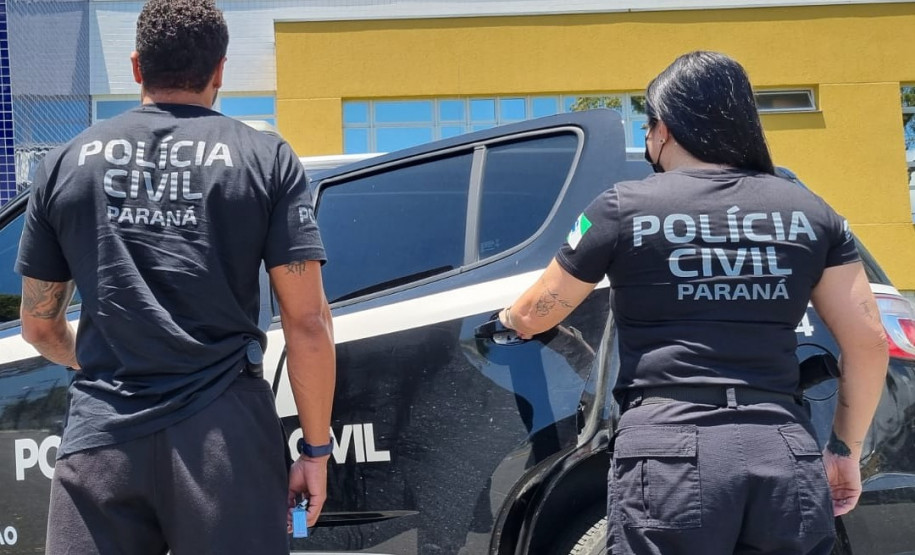 Dois policiais de costas entrando em viatura