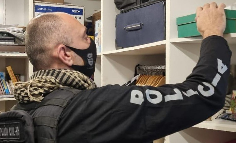 Policial civil procurando objetos em armário