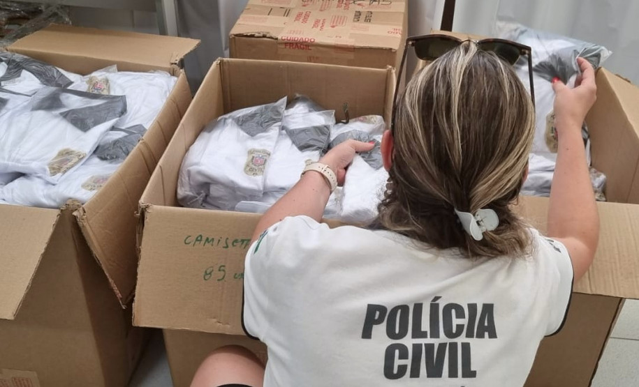 Policial civil verificando uniformes em diversas caixas abertas