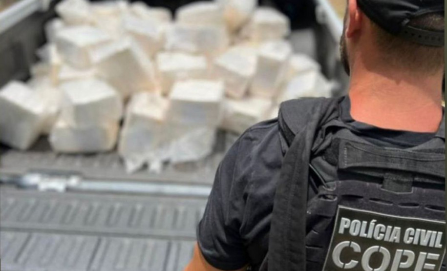 Policial civil ao lado de veiculo com drogas