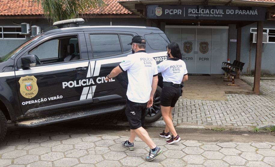 Dois policiais civis entrando em viatura