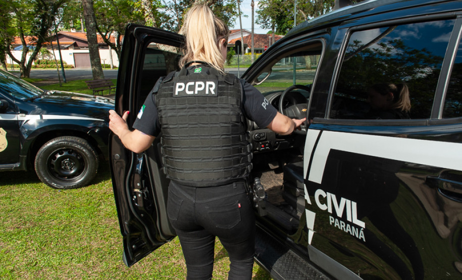 Policial civil entrando em viatura