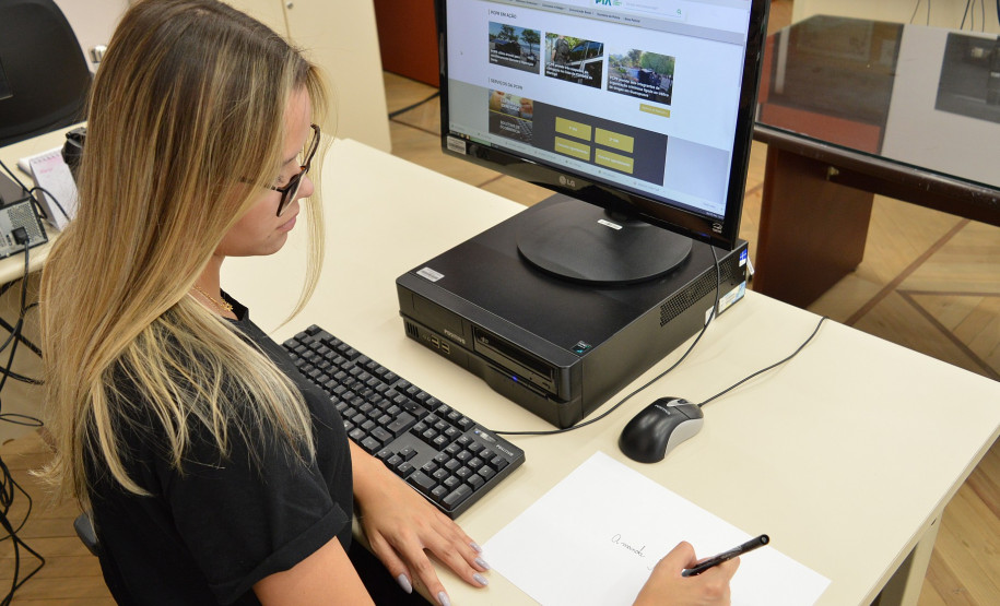 Mulher assina nome em folha em branco