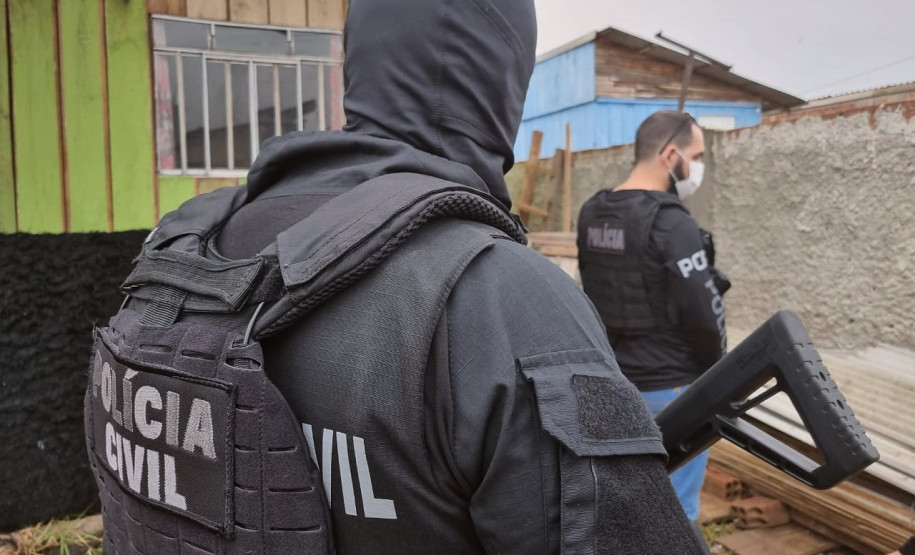 Dois policiais de costas no momento da operação