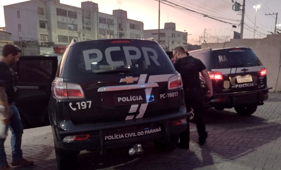 Dois policiais entrando em viatura