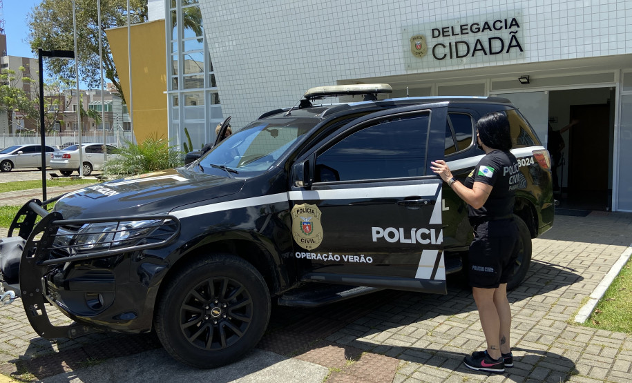 Policiais civis entrando em viatura em frente à delegacia de Matinhos