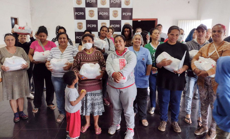 Beneficiados com entrega de cestas posam para foto