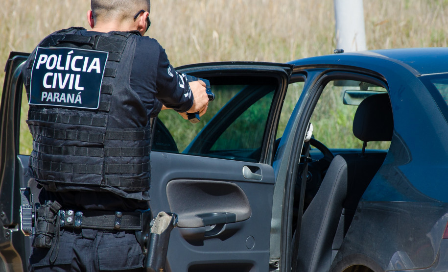 Policial civil aponta arma em direção a veículo suspeito