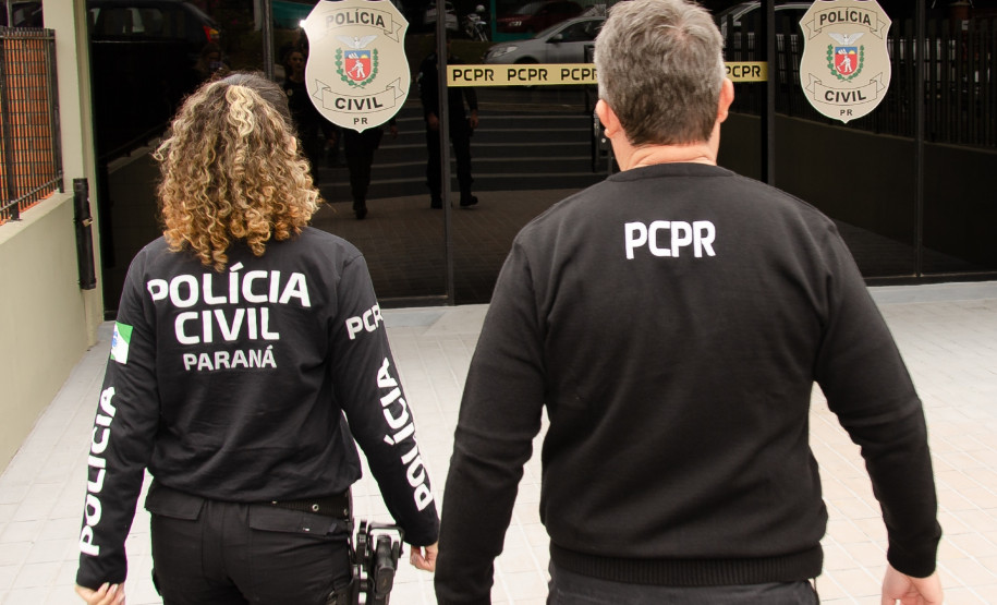 Dois policiais civis entrando em delegacia