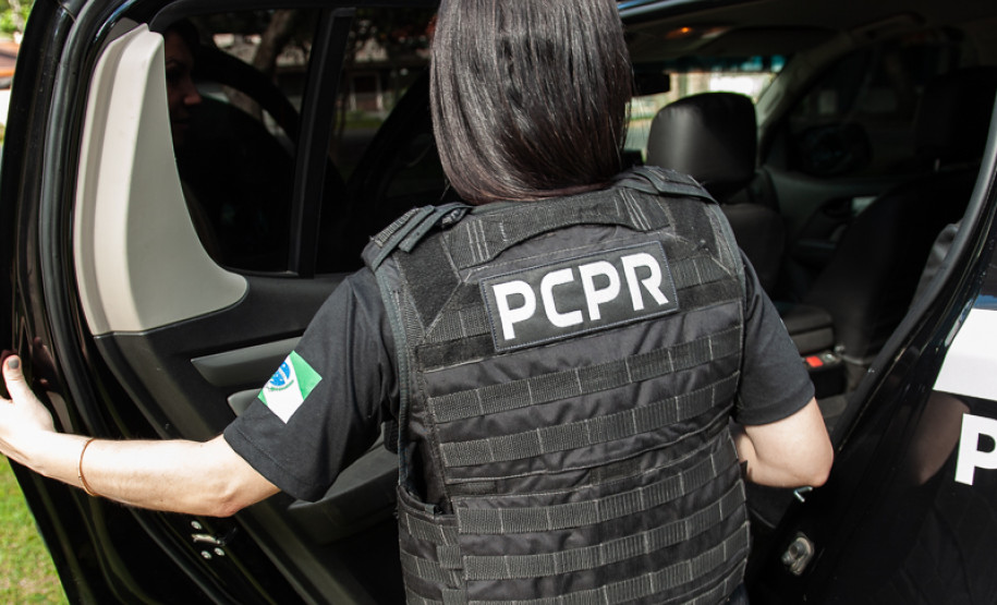 Policial civil entrando em viatura