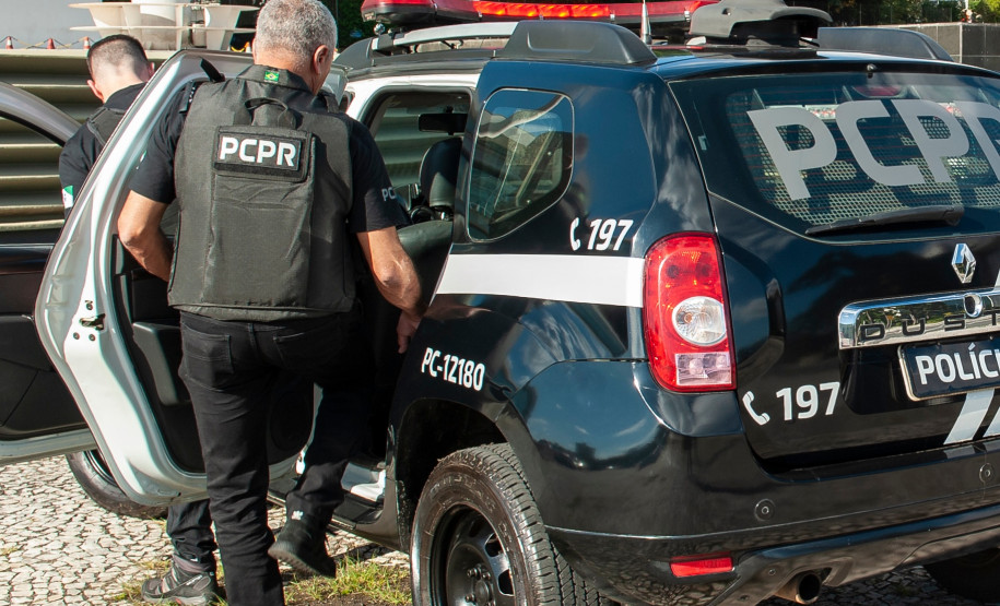 Policiais civis entrando em viatura