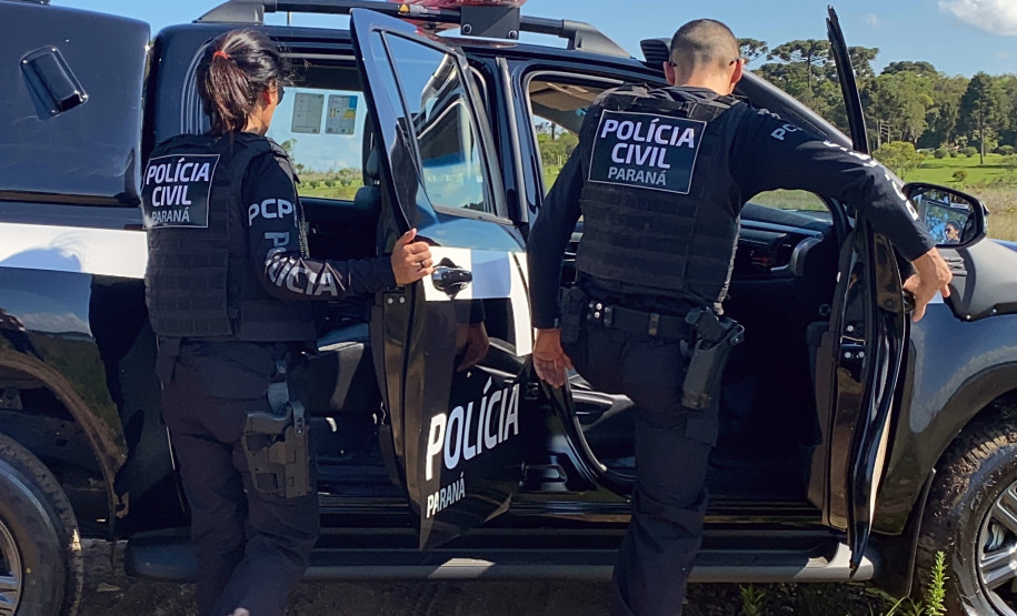 Dois policiais entrando em viatura