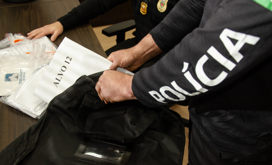 Policial civil com documentos e malote