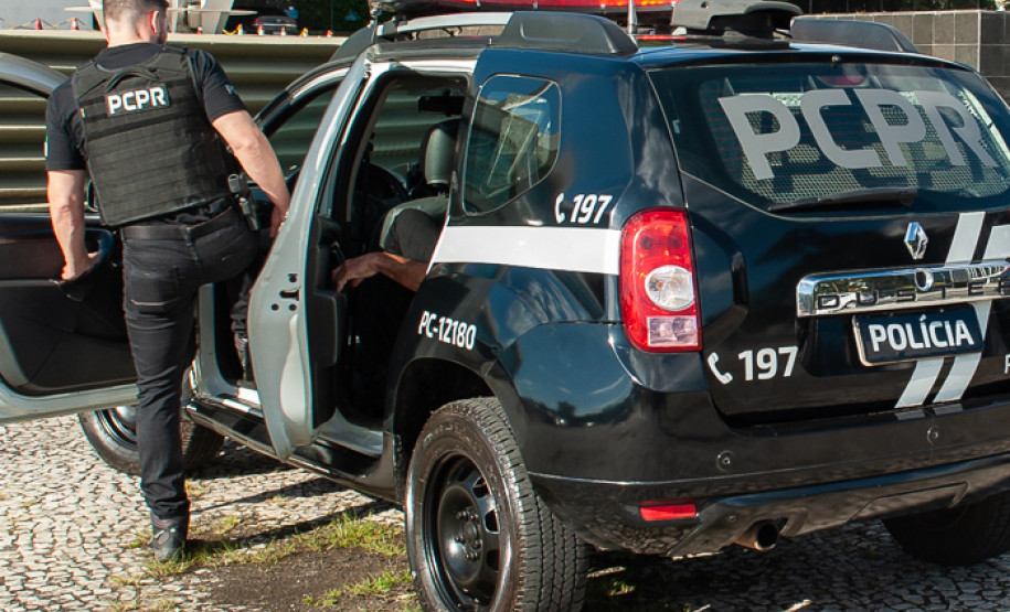 Policial civil entrando em viatura