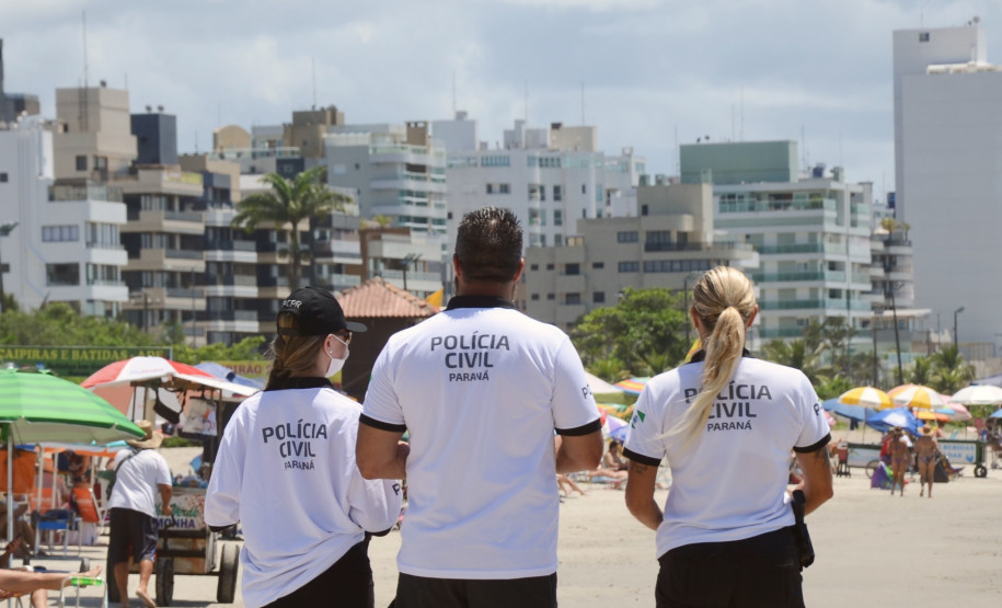 Três policiais civis observam o movimento no litoral