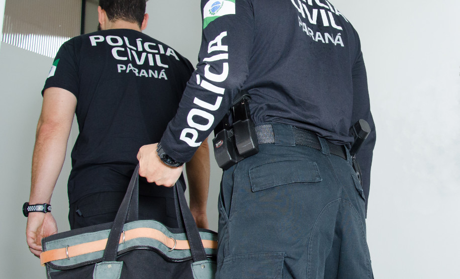 Dois policiais entrando em delegacia com malote