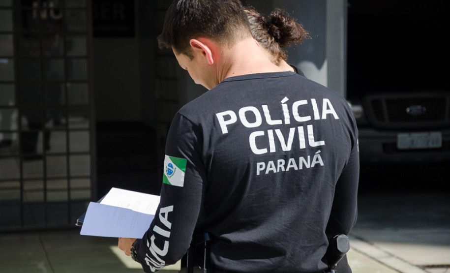 Dois policiais civis analisam documentos