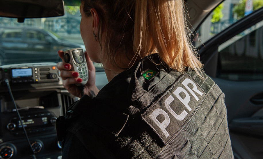 Policial civil falando ao rádio em viatura