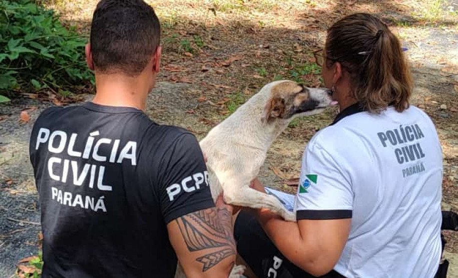 Dois policiais civis com um cão