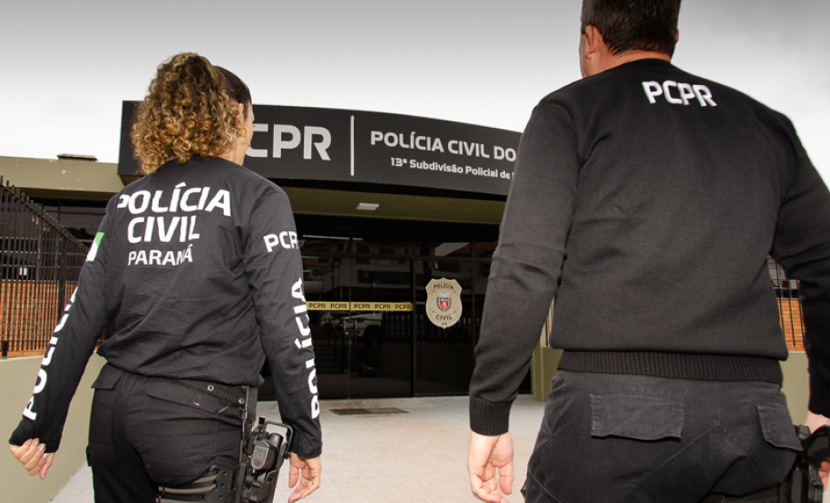 Dois policiais civis entrando em delegacia