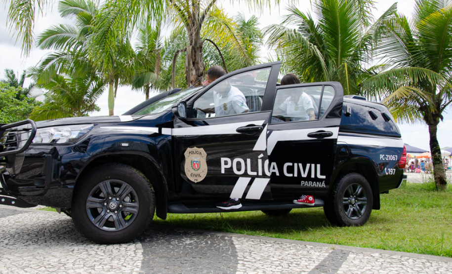 Dois policiais civis entrando em viatura