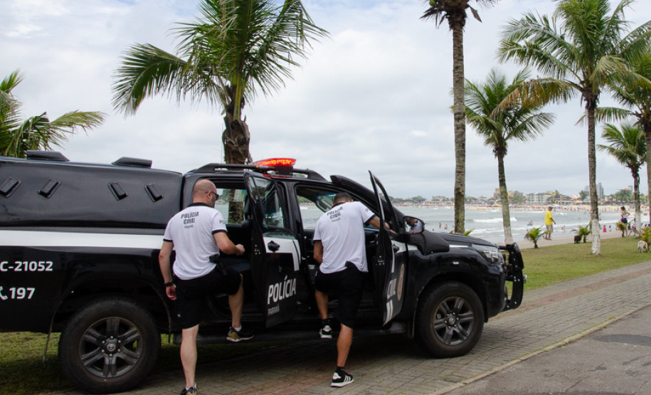 Dois policiais civis entrando em viatura