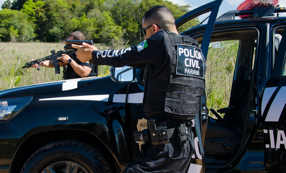 Dois policiais civis apontando arma em abordagem