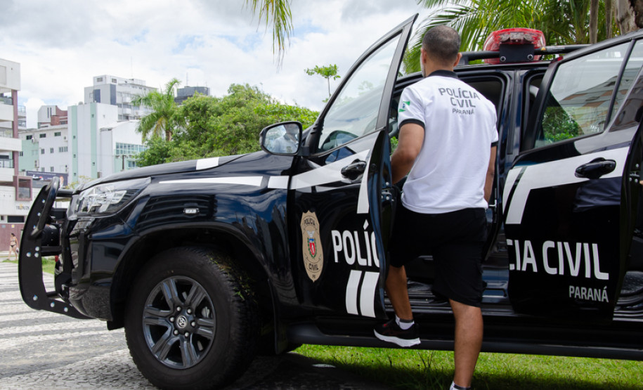 Policial civil entrando em viatura
