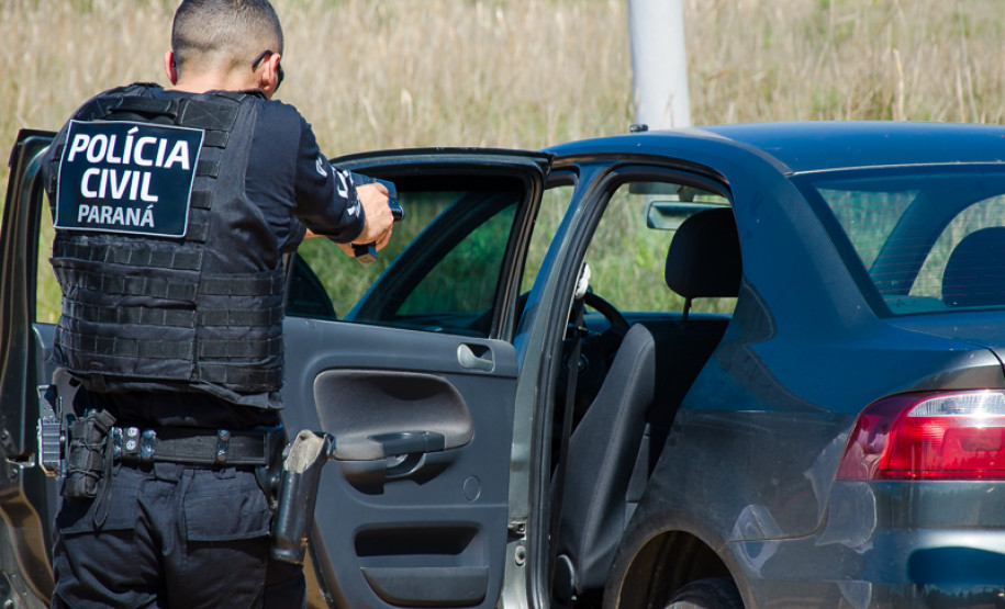 Policial civil apontando arma em abordagem a veiculo