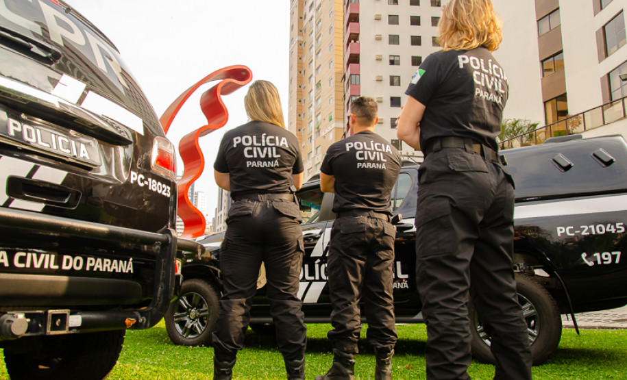 Três policiais civis entre viaturas