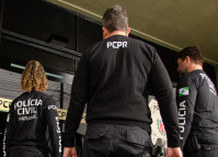 Três policiais civis entrando em delegacia