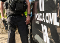 Policiail civil ao lado de viatura